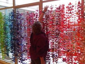 Kirby Capen's mother Judith hangs the paper cranes at the Smith Center